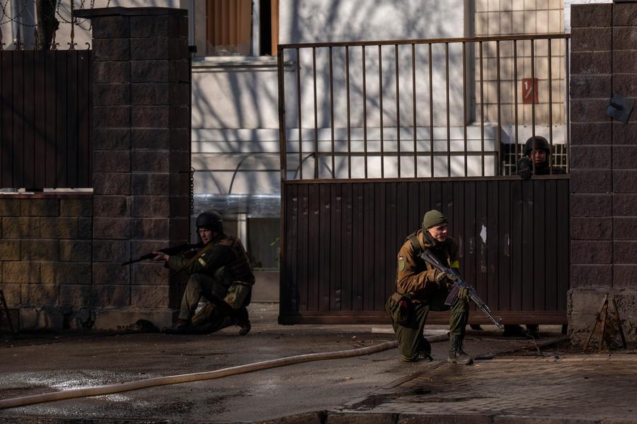 Ukrainian soldiers take positions outside a military facility after an explosion in Kyiv, Ukraine, Saturday, Feb. 26, 2022. Russian troops stormed toward Ukraine's capital Saturday, and street fighting broke out as city officials urged residents to take shelter. (AP Photo/Emilio Morenatti)