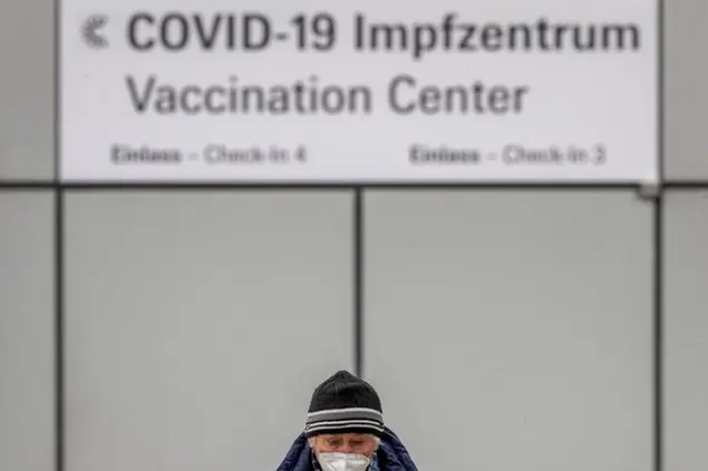 A man wears a face mask as he comes back from the vaccination center in Frankfurt, Germany, Thursday, Jan. 28, 2021. (AP Photo/Michael Probst)