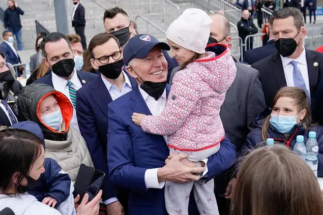 (Joe Biden a Varsavia, con il premier polacco e alcuni bambini arrivati dall'Ucraina. Foto AP)