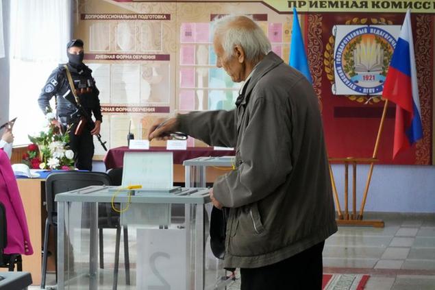 A man casts his ballot during a referendum in Luhansk, Luhansk People's Republic controlled by Russia-backed separatists, eastern Ukraine, Tuesday Sept. 27, 2022. Voting began Friday in four Moscow-held regions of Ukraine on referendums to become part of Russia. (AP Photo)