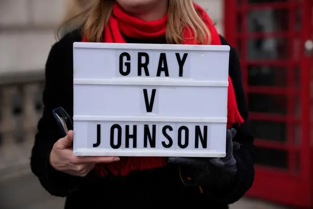 (Una manifestante protesta contro la leadership di Johnson evocando il rapporto Gray.\\u00A0Foto AP)