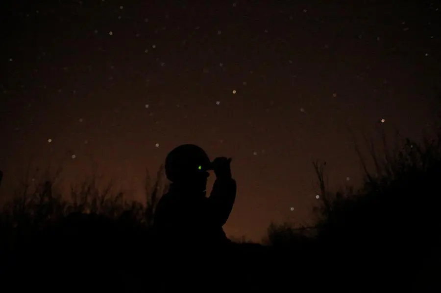 FILE - A Ukrainian soldier looks through a U.S.-made night-vision device in the front line in the town of Avdiivka in the Donetsk region, Ukraine, on Nov. 18, 2019. When Russia annexed Ukraine's Crimean Peninsula in 2014 and threw its support behind separatists in the country's east, Kyiv's underfunded and disorganized armed forces struggled to respond. Now, amid fears that a Russian troop buildup near Ukraine's border could signal a possible attack, military experts say there would be stronger resistance but that Ukraine would be well short of what it needs to counter Russia's overwhelming land, sea and air superiority. (AP Photo/Vitali Komar, File)