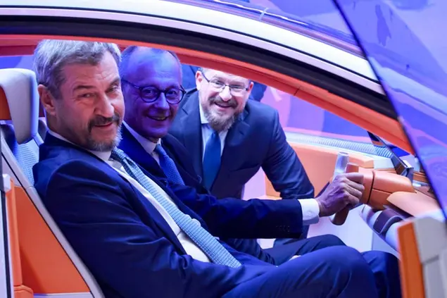 Il cancelliere Merz e il governatore della Baviera Söder alla fiera dell'automobile a Monaco