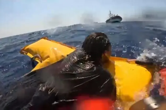 Un frame di un momento del salvataggio dei migranti che erano a bordo dei due barconi ribaltatisi a largo di Lampedusa (foto Ansa)