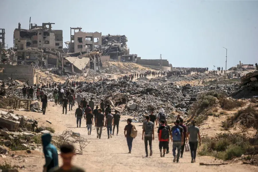 Palestinesi sfollati camminano lungo Rashid Road nella parte occidentale di Jabalia, nella Striscia di Gaza settentrionale