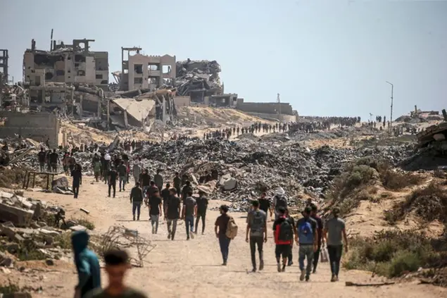 Palestinesi sfollati camminano lungo Rashid Road nella parte occidentale di Jabalia, nella Striscia di Gaza settentrionale