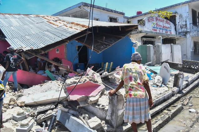 Una donna di fronte alla\\u00A0sua casa distrutta dal terremoto del 14 agosto ad Haiti (AP Photo/Duples Plymouth)