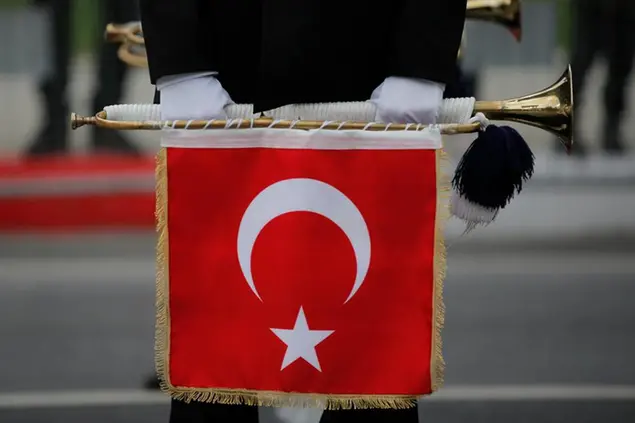 A Turkish soldier holds a trumpet with the Turkish flag as taking part in a parade during the celebration of Turkey's Republic Day in Istanbul, Friday, Oct. 29, 2021. Turkey is celebrating the 98th anniversary of modern Turkish Republic founded by Ataturk. (AP Photo/Emrah Gurel)