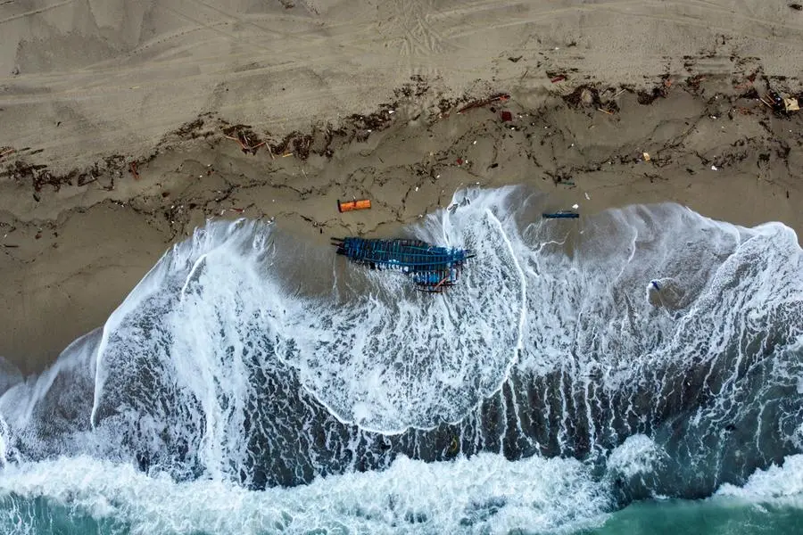 A view of part of the wreckage of a capsized boat that was washed ashore at a beach near Cutro, southern Italy, Monday, Feb. 27, 2023. Rescue crews searched by sea and air Monday for the dozens of people believed still missing from a shipwreck off Italy's southern coast that drove home once again the desperate and dangerous crossings of migrants seeking to reach Europe. (AP Photo/Luigi Navarra)