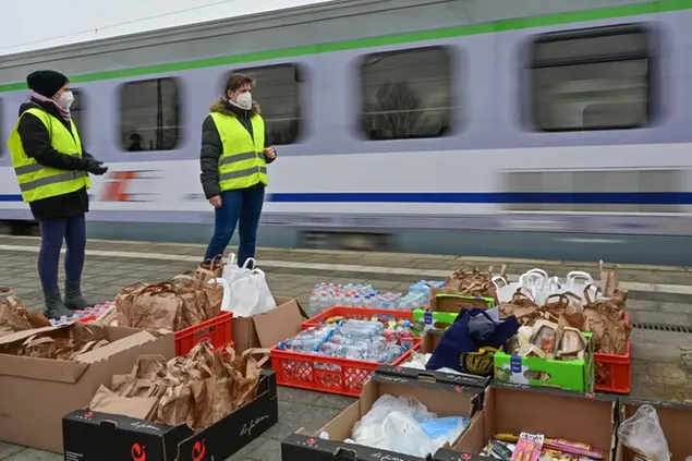 16 March 2022, Brandenburg, Frankfurt (Oder): Volunteer helpers stand next to food at the Frankfurt (Oder) train station while a train with war refugees from Ukraine arrives. Several special trains arrive here at the station every day, as well as regular trains from the Polish capital Warsaw with war refugees from Ukraine. All trains stop briefly in Frankfurt (Oder) while the federal police check the passengers. Many volunteers from various associations distribute food to the travelers. The German Red Cross is currently on site with 12 helpers. Photo by: Patrick Pleul/picture-alliance/dpa/AP Images