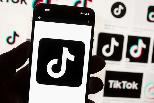 FILE - The TikTok logo is seen on a cell phone on Oct. 14, 2022, in Boston. North Dakota Gov. Doug Burgum has banned the popular social media app TikTok from devices owned by the state government's executive branch, joining several other Republican governors who have done so citing the platform's Chinese ownership and growing national security worries. (AP Photo/Michael Dwyer, File)