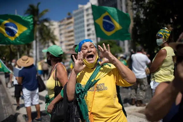 A supporter of Brazilian President Jair Bolsonaro jeers at opponents during a demonstration supporting Bolsonaro after leaders of all three branches of the armed forces jointly resigned following Bolsonaro’s replacement of the defense minister, on Copacabana beach in Rio de Janeiro, Brazil, Wednesday, March 31, 2021. (AP Photo/Silvia Izquierdo)
