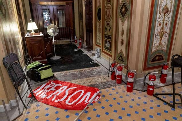 A flag that reads \\\"Treason\\\" is visible on the ground in the early morning hours of Thursday, Jan. 7, 2021, after protesters stormed the Capitol in Washington, on Wednesday. (AP Photo/Andrew Harnik)