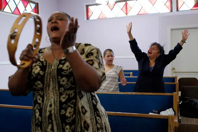 This March 21, 2010 photo shows church members Hillary Goxiola, right, and Debra Gatlin singing during a Sunday service at New Life in Christ Church in Los Angeles. Two years after this African-American Pentecostal congregation of about 100 people welcomed their Latino neighbors, the two groups are still trying to stay in tune in a part of the city that has not always lived in harmony. (AP Photo/Jae C. Hong)