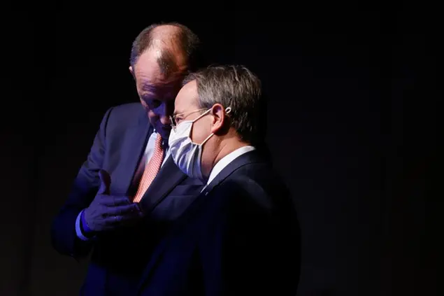 Candidate as leader of the Christian Democratic Union (CDU) Friedrich Merz, left, and North Rhine-Westphalia's Governor and candidate as leader of the Christian Democratic Union (CDU) Armin Laschet, right, talk behind the stage while the third candidate holds his speech on the second day of the party's 33rd congress held online because of the coronavirus pandemic, in Berlin on January 16, 2021. German Chancellor Angela Merkelâ€™s party is choosing a new leader on Saturday, eight months before voters decide who will succeed Merkel in a national election. (Odd Andersen/Pool via AP)