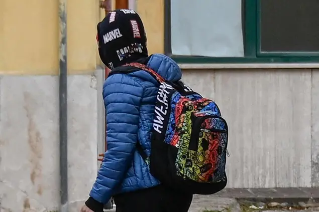 Un bambino con lo zaino mentre va a scuola
