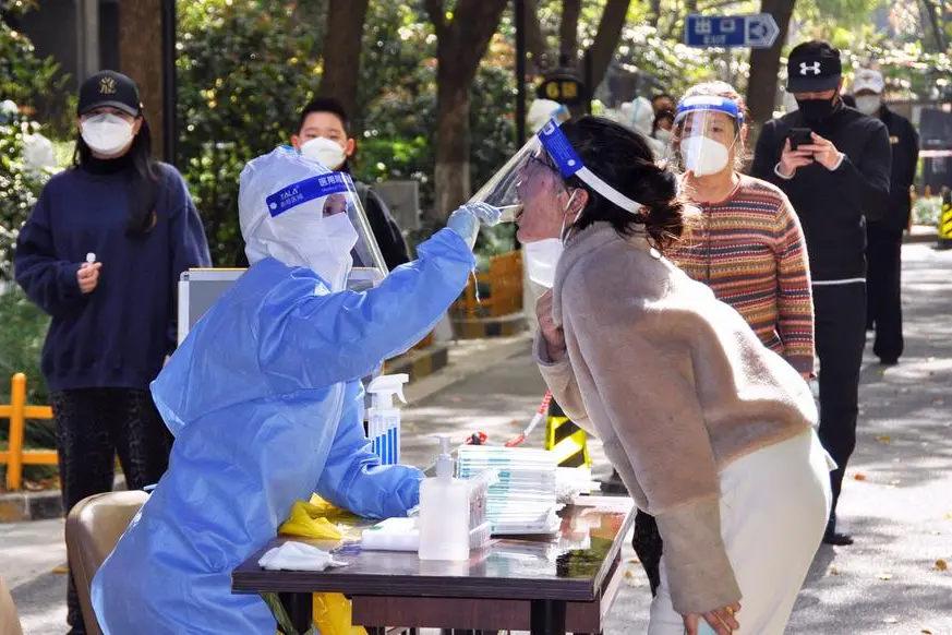 People take PCR tests in Shanghai on April 6, 2022, as a lockdown to curb coronavirus infections continues. (Kyodo via AP Images) ==Kyodo