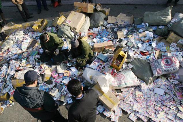 People prepare pirated video materials for destruction at a piracy crackdown ceremony in Changchun, China's Jilin province, Friday, Dec. 8, 2006. As the fifth anniversary of China's entry into the World Trade Organization (WTO) on Dec. 11, 2001 nears, concerns are still raised in regards to the widespread copyright piracy. (AP Photo) ** CHINA OUT **