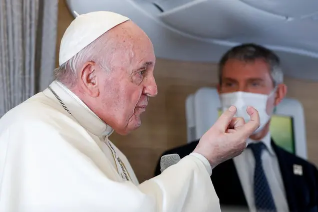 Pope Francis speaks to journalists, Monday, March 8, 2021, while flying back to The Vatican at the end of his four-day trip to Iraq where he met with different Christian communities and Shiite revered cleric Grand Ayatollah Ali al-Sistani. At right pope's spokesperson Matteo Bruni. (AP Photo/Yara Nardi, pool)