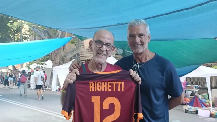Bambini e ragazzi giocano a calcio su un terreno di asfalto a Spin Time, un quartiere in crisi ma in movimento