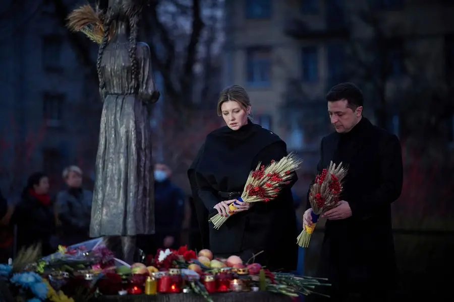 Ukrainian President Volodymyr Zelenskyy and his wife Olena visit a monument for Holodomor victims during a commemoration ceremony marking the 88th anniversary of the Great Famine of 1932-33, in which millions died of hunger, in Kyiv, Ukraine, Saturday Nov. 27, 2021. Church bells tolled, candles flickered and national flags, adorned with black ribbons, flew in the Ukrainian capital Kyiv Saturday as the country marked the anniversary of the start of a Soviet-era famine.(Ukrainian Presidential Press Office via AP)