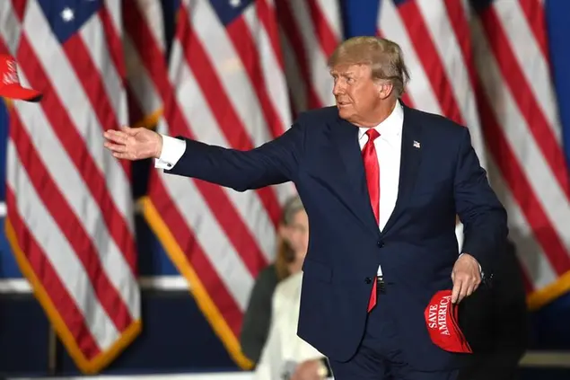Former President Donald Trump tosses caps to the crowd as he steps onstage during a rally at the Macomb Community College Sports & Expo Center in Warren, Mich., Saturday, Oct. 1, 2022. (Todd McInturf/Detroit News via AP)