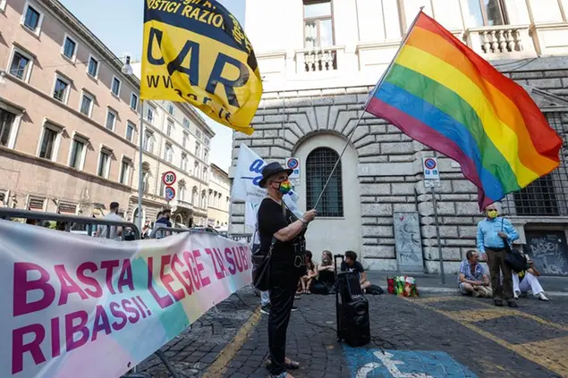 LGBT activists attend a protest near the Senate, asking for the approval of a law promoted by Democratic Party's lawmaker Alessandro Zan, aimed to extend further protections from discrimination to the LGBT community, in Rome, Tuesday, July 20, 2021. The banner at right reads 'Stop rebates! Law Zan now!' (AP Photo/Riccardo De Luca)