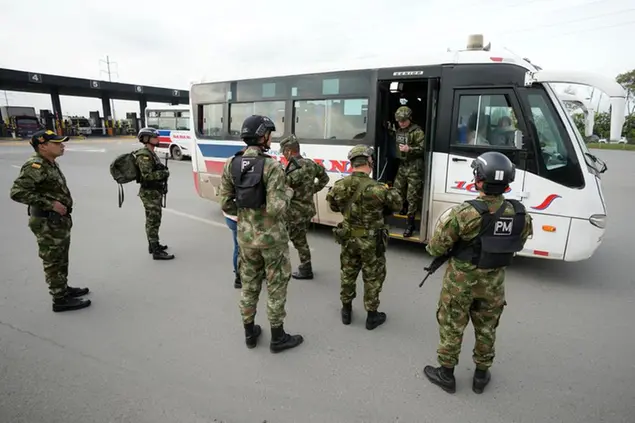Soldiers talk to bus commuters along a toll road in Bogota, Colombia, Friday, June 17, 2022. Security is heightened ahead of Sunday's presidential runoff election between the man who could become the first leftist to lead the nation and a populist millionaire who promises to end corruption. (AP Photo/Fernando Vergara)