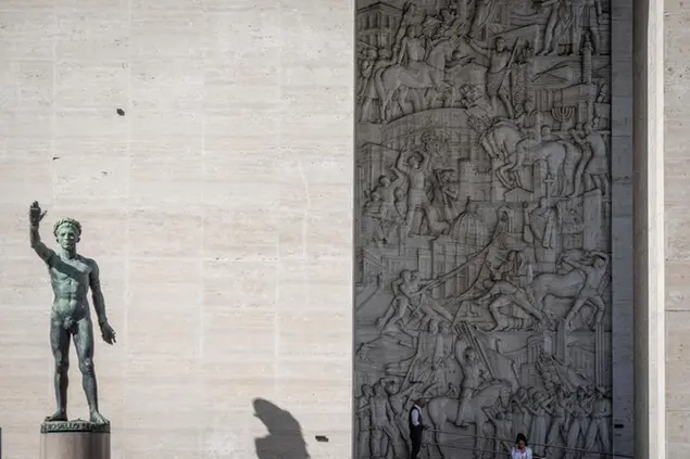 19 October 2022, Italy, Rom: People stand in front of the entrance of Palazzo degli Uffici in front of a relief by artist Publio Morbiducci that shows, among others, former Italian dictator Mussolini sitting on a horse. (to dpa \\\"Ahead of 100th anniversary of the seizure of power by the fascists in Italy\\\") Photo by: Oliver Weiken/picture-alliance/dpa/AP Images