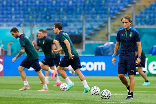 Italy's head coach Roberto Mancini, right, looks at his players as they work out during a training session of the national soccer team at the Olympic stadium in Rome, Thursday, June 10, 2021, ahead of their match against Turkey on Friday June 11. The Euro 2020 gets underway on Friday June 11 and is being played in 11 host cities across 11 countries. The event was delayed by one year after being postponed in 2020 due to the COVID-19 pandemic. (AP Photo/Alessandra Tarantino)