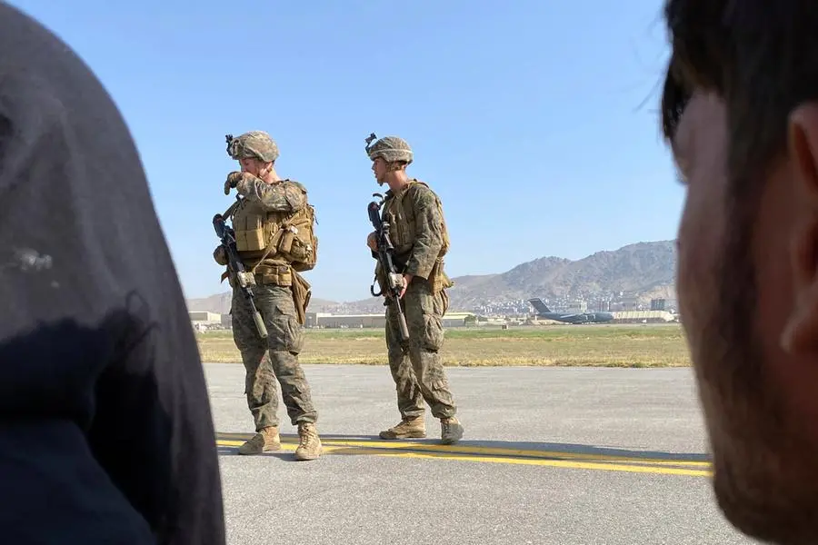 U.S soldiers stand guard along a perimeter at the international airport in Kabul, Afghanistan, Monday, Aug. 16, 2021. On Monday, the U.S. military and officials focus was on Kabul’s airport, where thousands of Afghans trapped by the sudden Taliban takeover rushed the tarmac and clung to U.S. military planes deployed to fly out staffers of the U.S. Embassy, which shut down Sunday, and others. (AP Photo/Shekib Rahmani)