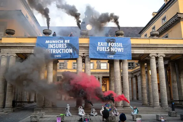 Activists from the group Extinction Rebellion demonstrate at Munich Re's headquarters and have placed posters reading \\\"Munich Re destruction\\\" and \\\"Exit Fossil Fuels now\\\" on the building in Munich, Germany, on Thursday, April 28, 2022. The activists are demanding, among other things, an exit from fossil fuels. Munich Reinsurance Company's annual general meeting will be held on April 28, 2022. (Sven Hoppe/dpa via AP)