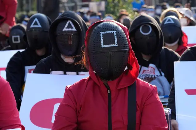 Members of the South Korean Confederation of Trade Unions wearing masks and costumes inspired by the Netflix original Korean series \\\"Squid Game\\\" attend a rally demanding job security in Seoul, South Korea, Wednesday, Oct. 20, 2021. Thousands of workers gathered ignoring the government's call to cancel the assembly feared to affect the fight against COVID-19. (AP Photo/Ahn Young-joon)