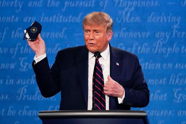 Una foto del 29 settembre, con Trump che sventola la mascherina durante il primo dibattito presidenziale a Cleveland (Foto AP/Julio Cortez)