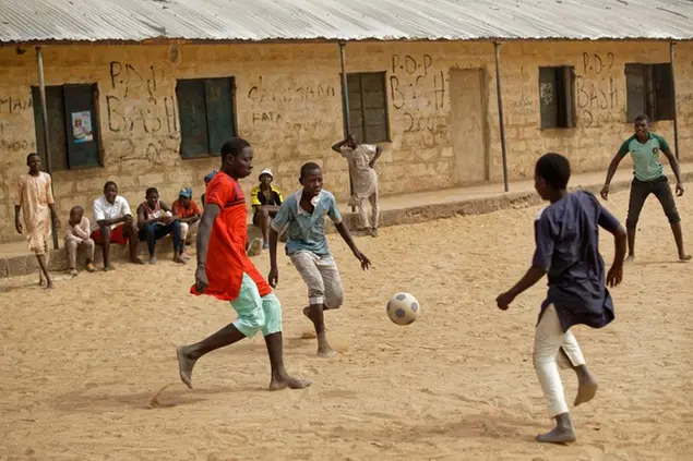 Children play football in the sandy courtyard of Badawa Girls School, which would have been used as a polling station, in Kano, northern Nigeria, Saturday, Feb. 16, 2019. A civic group monitoring Nigeria's now-delayed election says the last-minute decision to postpone the vote a week until Feb. 23 \\\"has created needless tension and confusion in the country.\\\" (AP Photo/Ben Curtis)