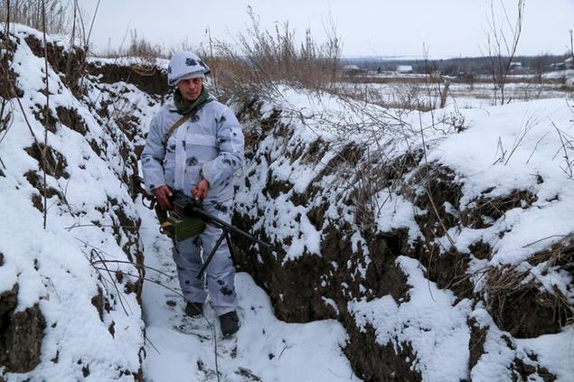 A serviceman stands holding his machine-gun in a trench on the territory controlled by pro-Russian militants at frontline with Ukrainian government forces in Slavyanoserbsk, Luhansk region, eastern Ukraine, Tuesday, Jan. 25, 2022. Ukraine's leaders sought to reassure the nation that a feared invasion from neighboring Russia was not imminent, even as they acknowledged the threat is real and prepared to accept a shipment of American military equipment Tuesday to shore up their defenses. (AP Photo/Alexei Alexandrov)