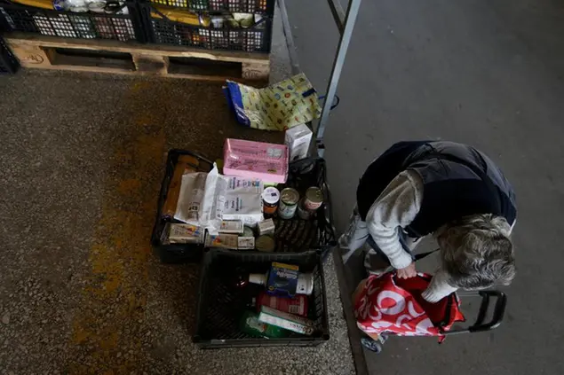 Foto Cecilia Fabiano /LaPresse 24-11-2022 Roma, Italia - Cronaca - Povertà , alcune famiglie si recano alla sede della Croce Rossa per ricevere i pacchi degli aiuti alimentari - Nella Foto : la distribuzione degli aiuti alimentari November 24, 2022 Rome Italy - News - Poverty, some families go to the headquarters of the Red Cross to receive parcels of food aid In The Photo : the distribution of the food aid