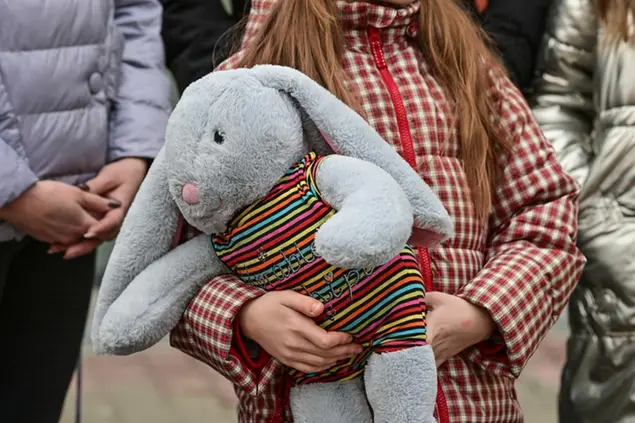 26 February 2022, Poland, Slubice: A girl of the Ukrainian Czuzman family from Lviv (German Lemberg) carries a cuddly toy in her arms upon arrival. The father of the Ukrainian Czuzman family, who works in Slubice, had picked up his family from the Polish-Ukrainian border. Now the seven family members live in the house of a Polish family. The first war refugees from Ukraine arrived in Frankfurt (Oder) and the neighboring Polish city of Slubice on the same day. Photo by: Patrick Pleul/picture-alliance/dpa/AP Images