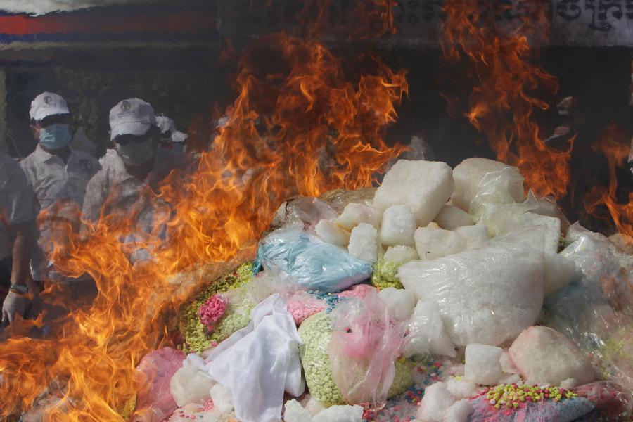 Cambodian authorities burn a pile of drugs during an event to mark the International Day Against Drug Abuse and Illicit Trafficking, in Phnom Penh, Cambodia, Friday, June 26, 2020. Some 500 kilograms of drugs were torched as part of a campaign to wipe out synthetic drugs recently uncovered in the country. (AP Photo/Heng Sinith)