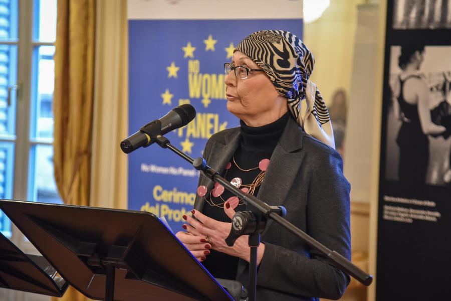 Tavolo riunione con documenti amministrativi e simboli della cultura italiana in primo piano