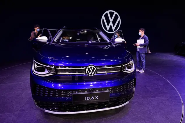 Visitors look at the latest electric car from Volkswagen during the Shanghai Auto Show in Shanghai on Tuesday, April 20, 2021. Automakers are looking to China, the biggest auto market by sales volume and the first major economy to rebound from the pandemic, to propel a revival in demand and reverse multibillion-dollar losses. (AP Photo/Ng Han Guan)