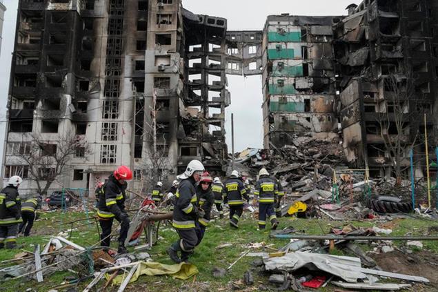 Emergency workers carry debris from a multi-storey building destroyed in a Russian air raid at the beginning of the Russia-Ukraine war in Borodyanka, close to Kyiv, Ukraine, Saturday, April 9, 2022. (AP Photo/Efrem Lukatsky)