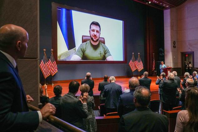 Members of Congress give Ukraine President Volodymyr Zelensky a standing ovation before he speaks in a virtual address to Congress in the U.S. Capitol Visitors Center Congressional Auditorium in Washington, Wednesday, March 16, 2022. (Sarahbeth Maney/The New York Times via AP, Pool)