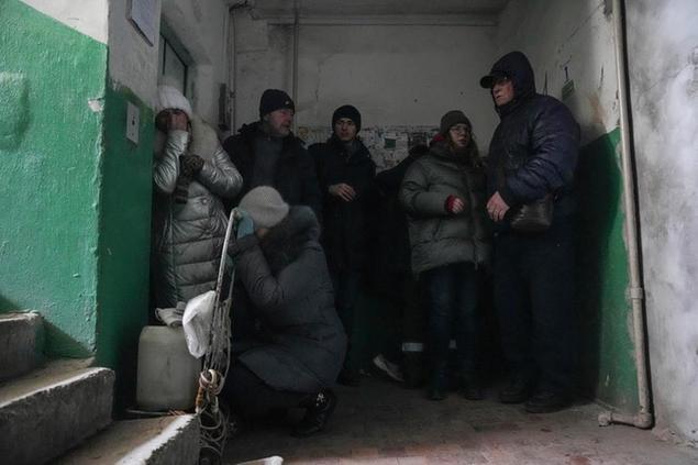 People cover from shelling inside an entryway to an apartment building in Mariupol, Ukraine, Sunday, March 13, 2022. (AP Photo/Evgeniy Maloletka)