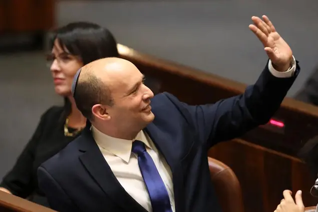 Israel's designated new prime minister Naftali Bennett sends greetings during a Knesset session in Jerusalem Sunday, June 13, 2021. Bennett is expected later Sunday to be sworn in as the country's new prime minister, ending Prime Minister Benjamin Netanyahu's 12-year rule. (AP Photo/Ariel Schali22