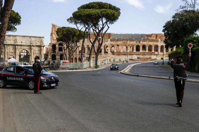 Carabinieri police officers stop a car at a road block near the Colosseum, in downtown Rome, Saturday, April 3, 2021. Italy went into lockdown on Easter weekend in its effort to battle then Covid-19 pandemic. (AP Photo/Gregorio Borgia)