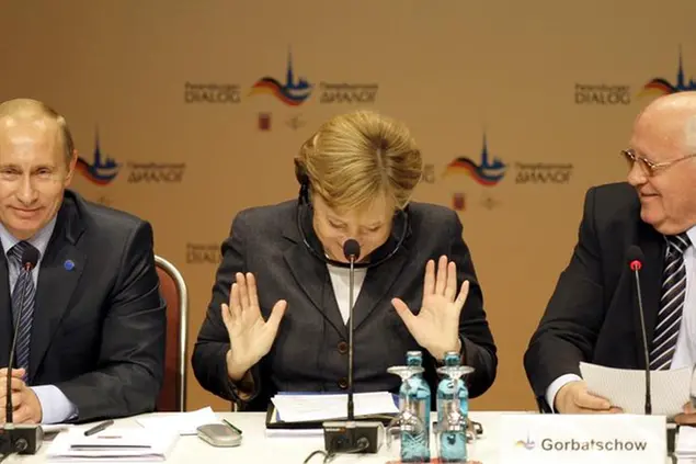 German Chancellor Angela Merkel, center, gestures as she, Russian President Vladimir Putin, left, and former President of the Soviet Union, Mikhail Gorbachev, right, attend the Petersburg Dialogue at the Kurhaus resort in Wiesbaden, Germany, Monday, Oct. 15, 2007. Putin is on a two-day visit to Germany for talks between Germany and Russia. (AP Photo/Anja Niedringhaus)