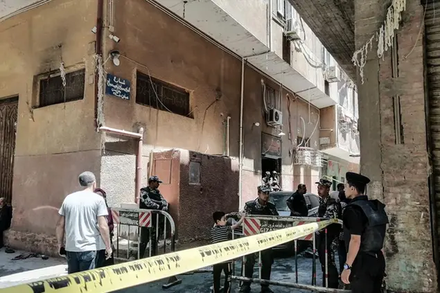 14 August 2022, Egypt, Gize: Security personnel stand at the cordoned scene where a massive fire broke out during a Sunday service at the Abu Sefein Coptic church in Giza. At least 41 people have died and dozens were severely injured after a mass fire broke out at the Coptic church. Photo by: Mahmoud El-Khawas/picture-alliance/dpa/AP Images