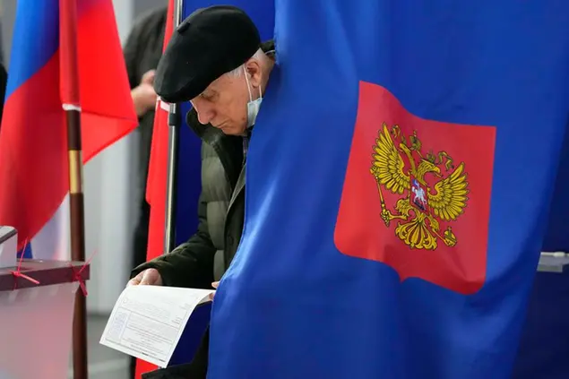 A man examines his ballot during the State Duma, the Lower House of the Russian Parliament and local parliament elections at a polling station in St. Petersburg, Russia, Sunday, Sept. 19, 2021. The head of Russia's Communist Party, the country's second-largest political party, is alleging widespread violations in the election for a new national parliament in which his party is widely expected to gain seats. (AP Photo/Dmitri Lovetsky)