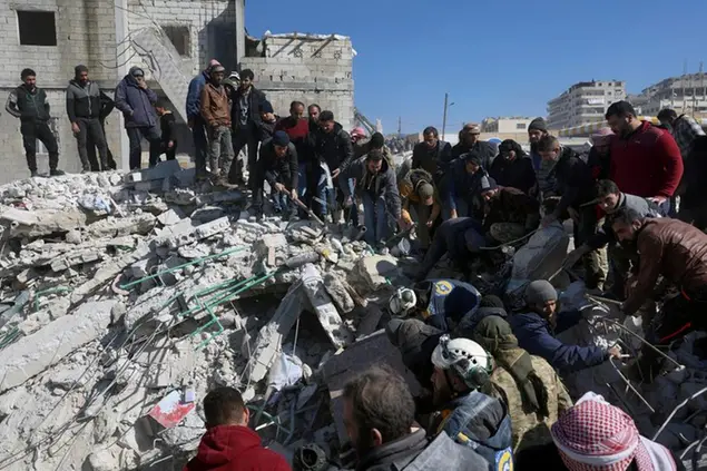 Rescuers and residents search through the rubble of collapsed buildings in the town of Harem near the Turkish border, Idlib province, Syria, Wednesday, Feb. 8, 2023. With the hope of finding survivors fading, stretched rescue teams in Turkey and Syria searched Wednesday for signs of life in the rubble of thousands of buildings toppled by a catastrophic earthquake. (AP Photo/Ghaith Alsayed)